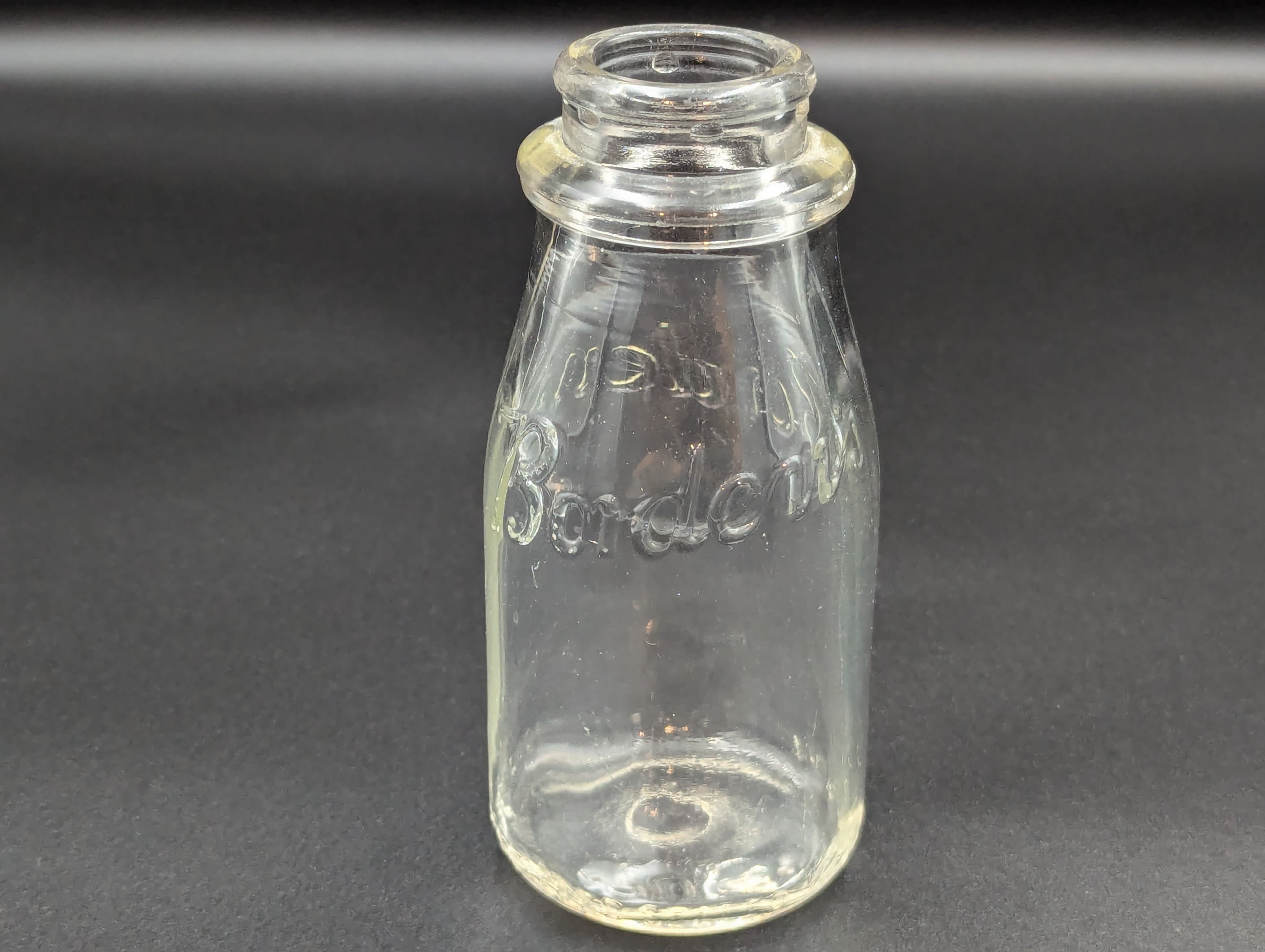 It is hard to see, but it says "Borden's" in scripted letters. The two bottles slightly differ.