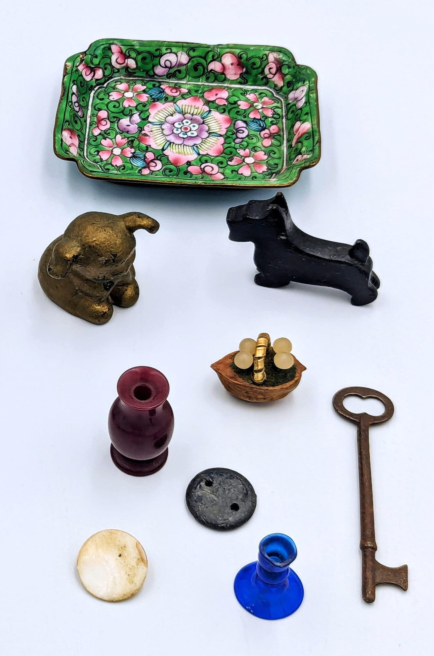 The gold doggie is made of metal.  The scottie dog is made of wood.